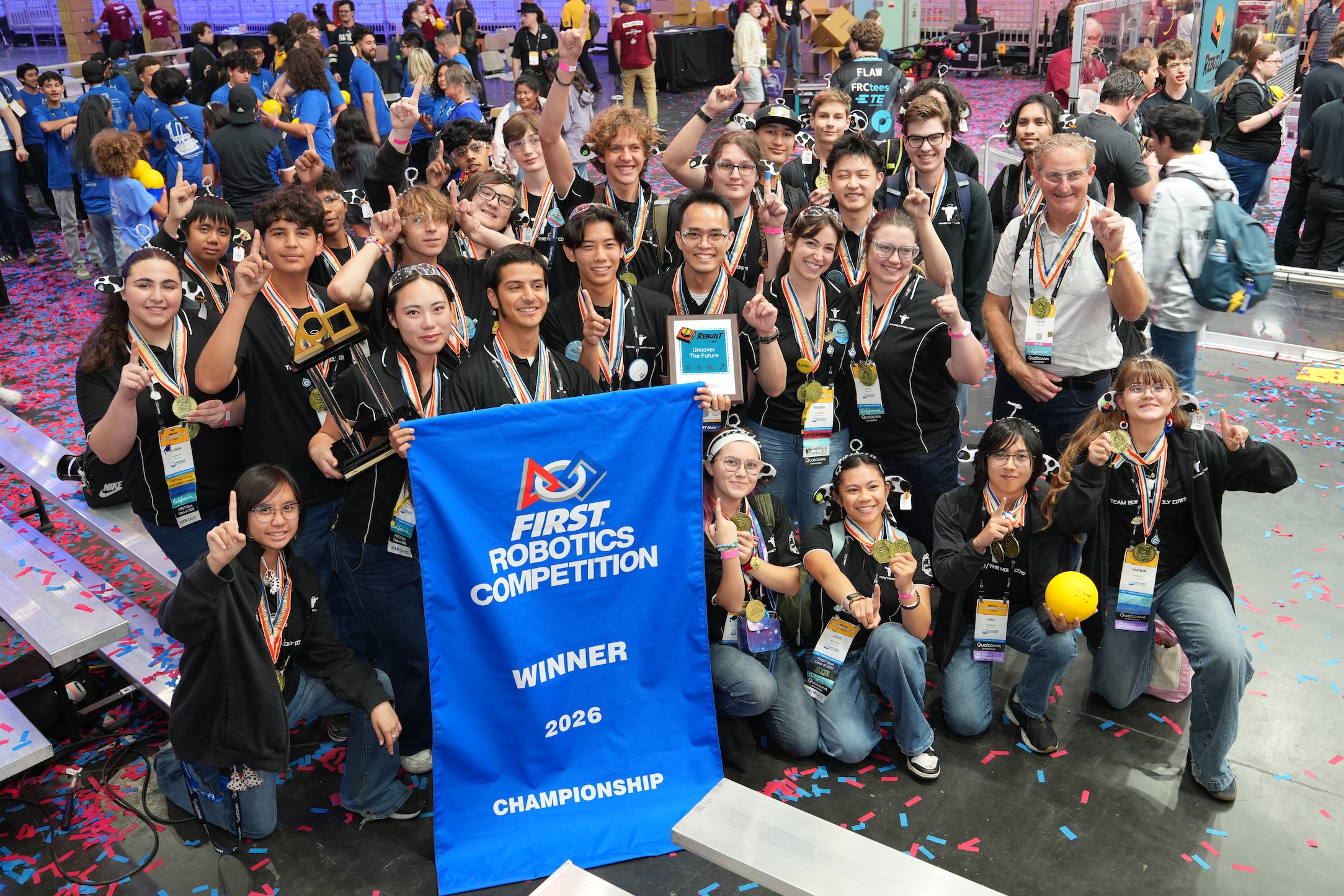 Team 1538 The Holy Cows celebrating their 2026 FIRST Robotics Competition Championship win with the winner banner